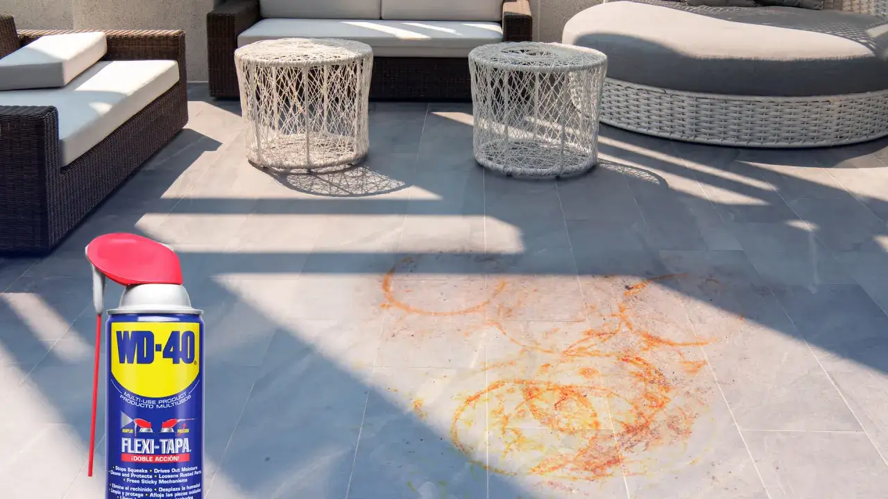 WD-40 listo para ayudarte a saber como quitar el óxido del suelo. Manchas naranjas en baldosas grises de terraza.