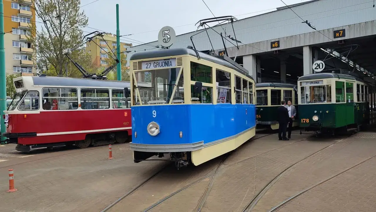 Trzy zabytkowe tramwaje MPK Poznań: czerwony, niebieski i zielony, stoją na torach przy zajezdni.