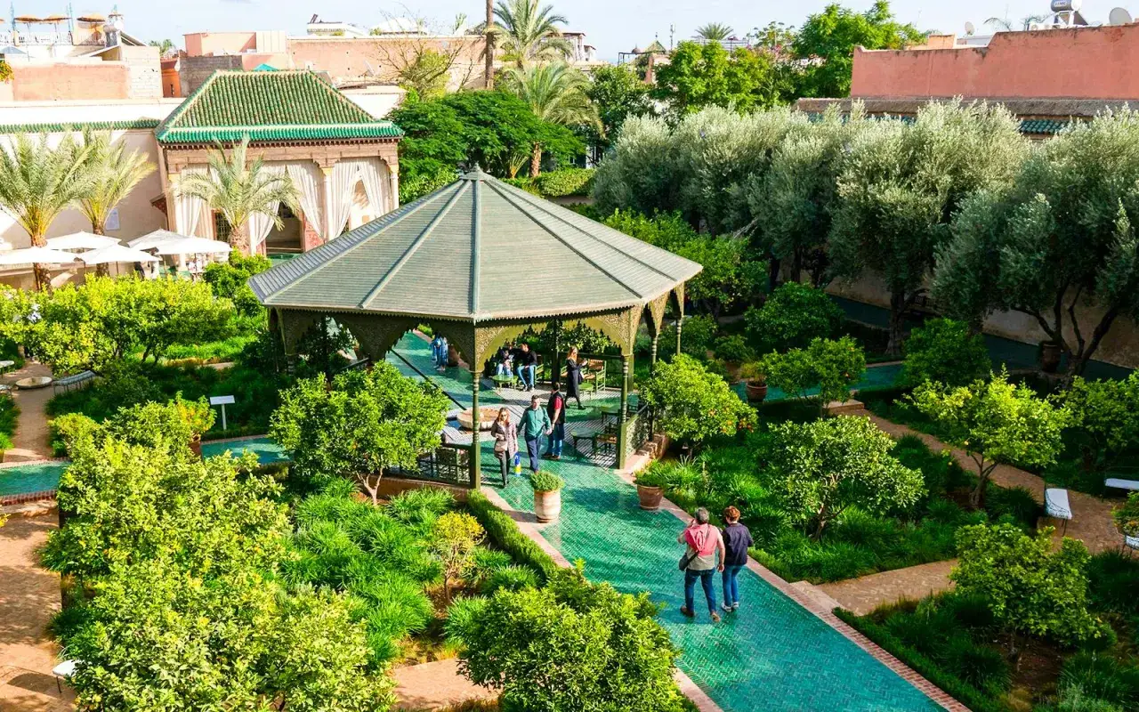 Un jardín exuberante con un pabellón central y caminos verdes. Un lugar ideal que visitar en Marrakech para disfrutar de la tranquilidad.