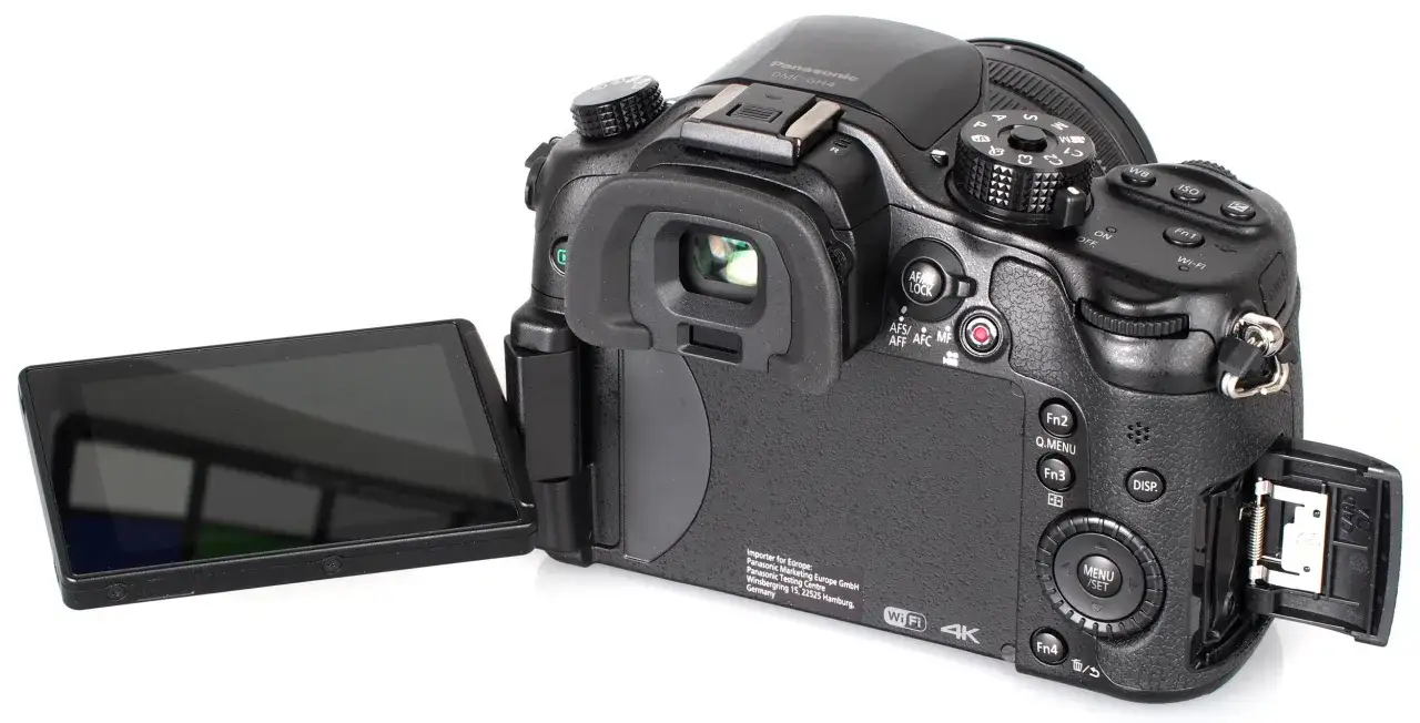Tył aparatu Panasonic Lumix GH4 z uchylnym ekranem i otwartą klapką karty pamięci.