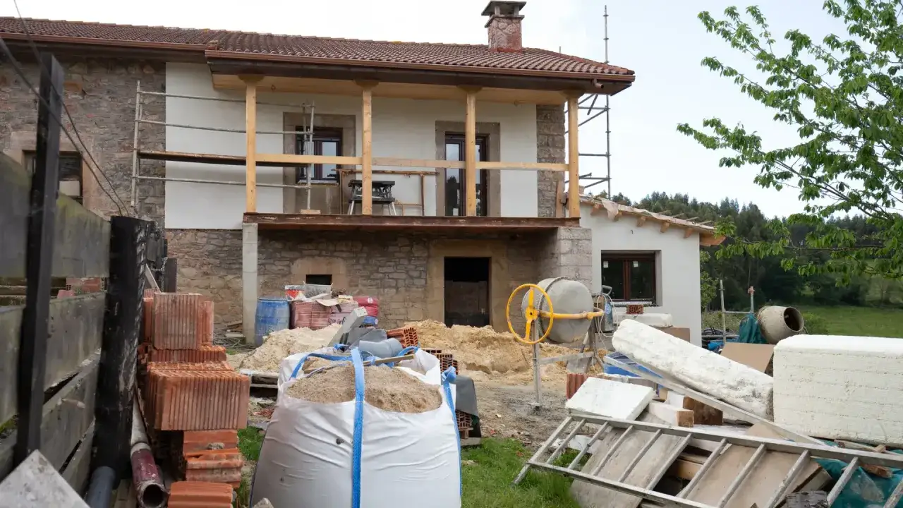 Construcci&oacute;n de una casa barata en Espa&ntilde;a: materiales como ladrillos, arena y cemento listos para obra.