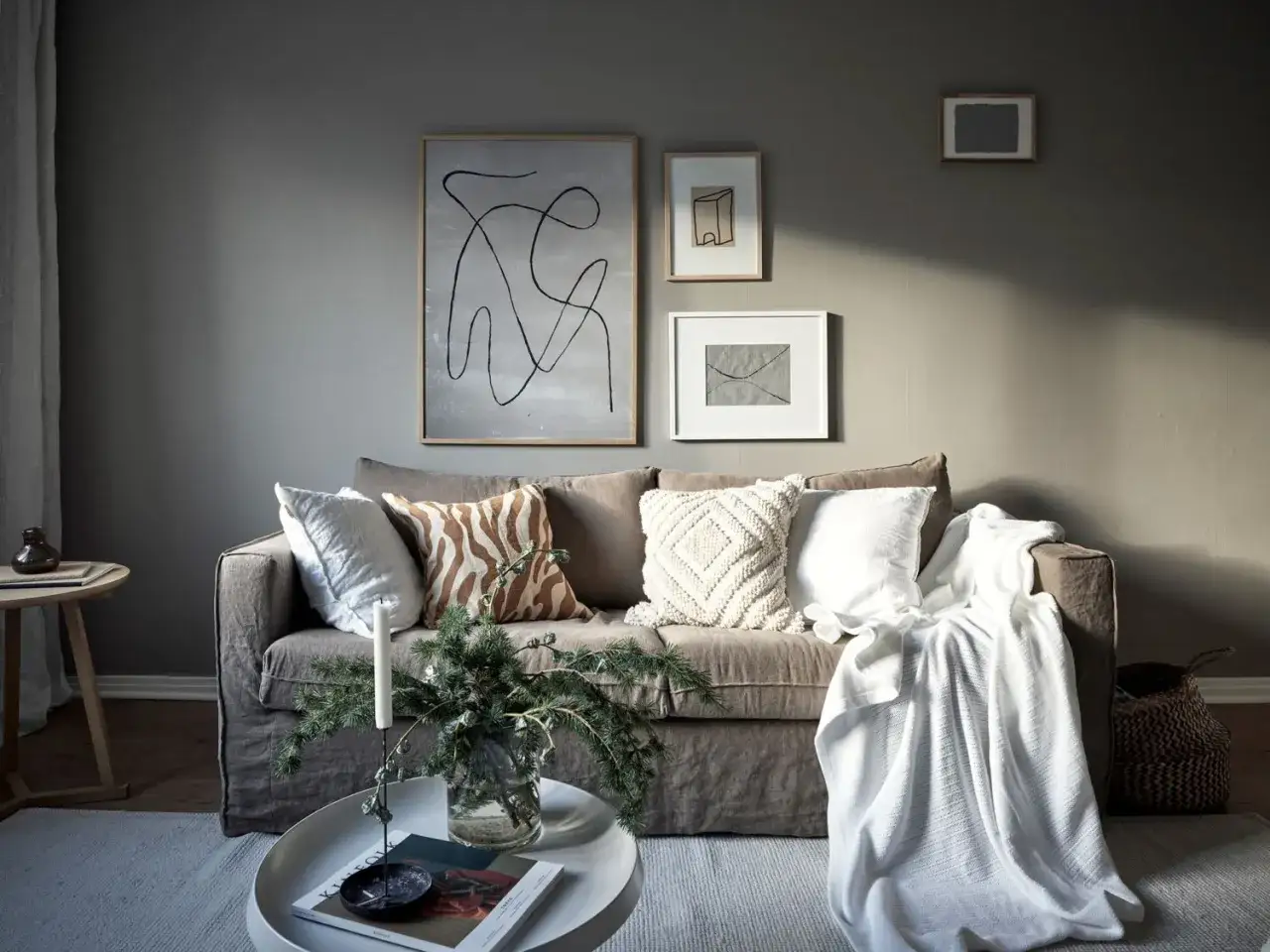 Canap&eacute; gris clair, coussins textur&eacute;s, plaid blanc et art abstrait. Quelle d&eacute;co avec canap&eacute; gris clair !