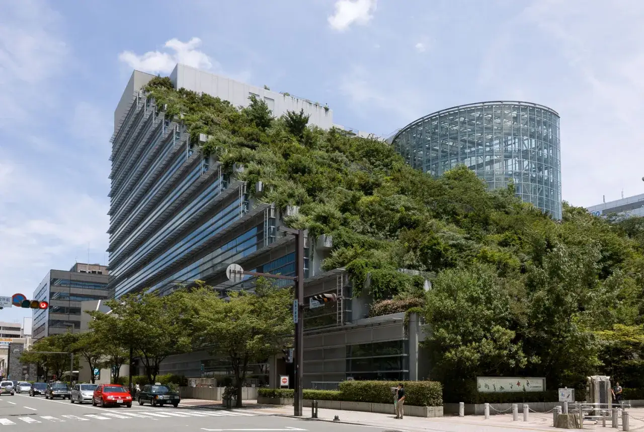 Edificio moderno cubierto de vegetaci&oacute;n, un ejemplo de **eficiencia energ&eacute;tica en arquitectura**.