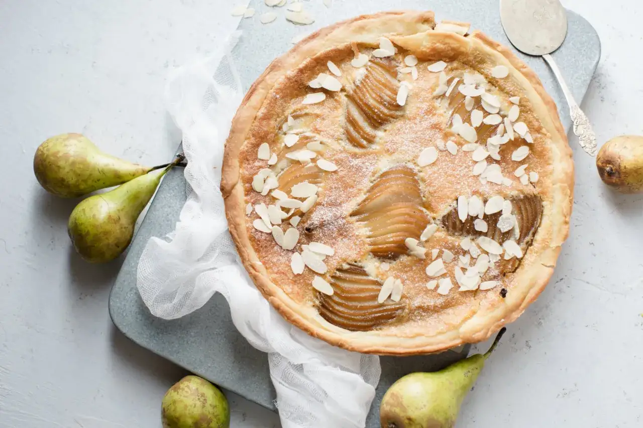 Tarte Bourdaloue aux poires, garnie d'amandes effilées. Une délicieuse recette à découvrir.
