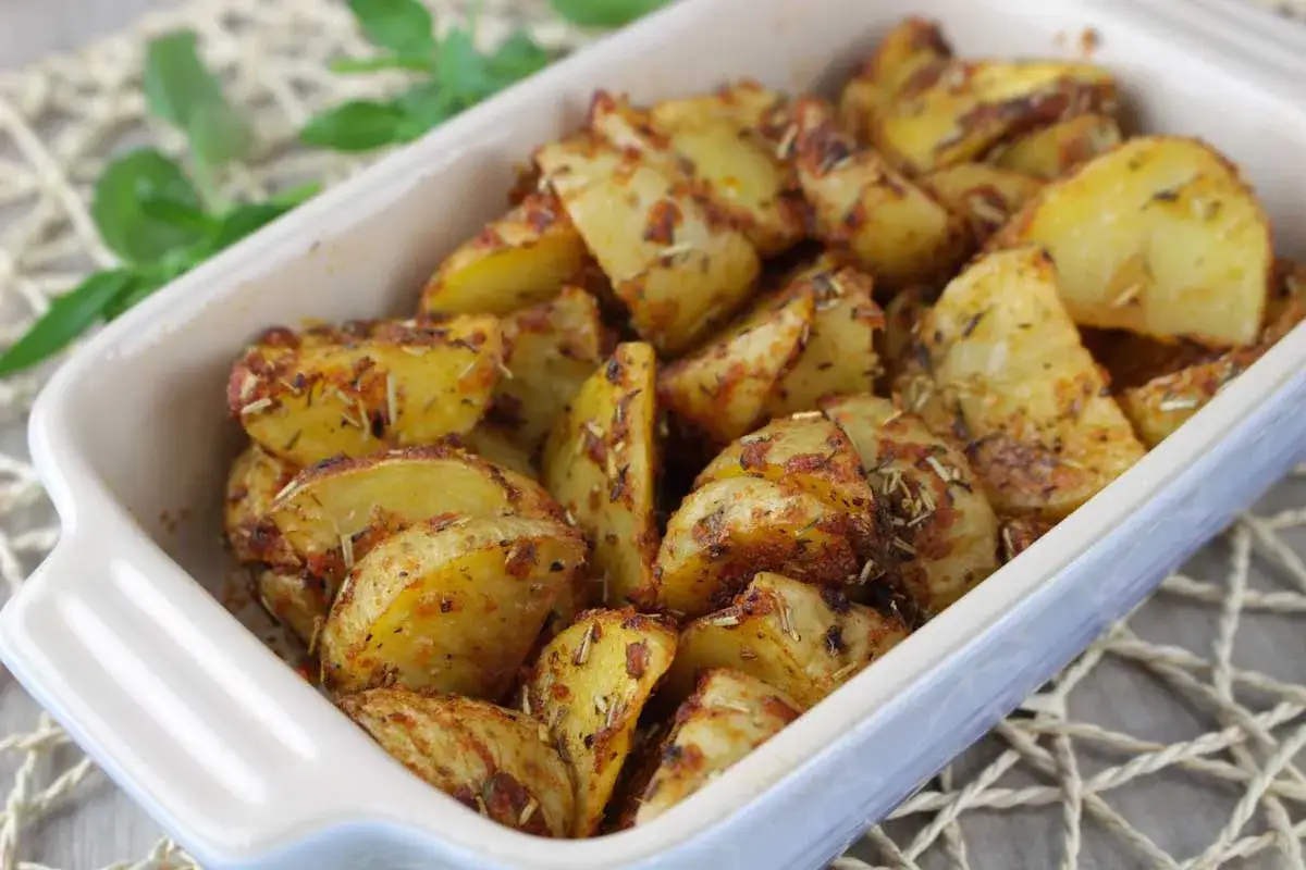 Patatas al microondas, cortadas en gajos y sazonadas con hierbas, listas para disfrutar.