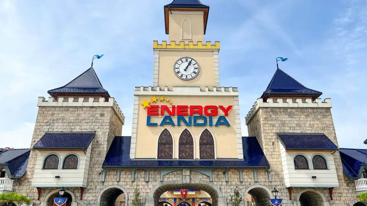 Brama Energylandii z zegarem i napisem. Zastanawiasz się, ile kosztuje bilet do Energylandii? Sprawdź ceny i zaplanuj wizytę!