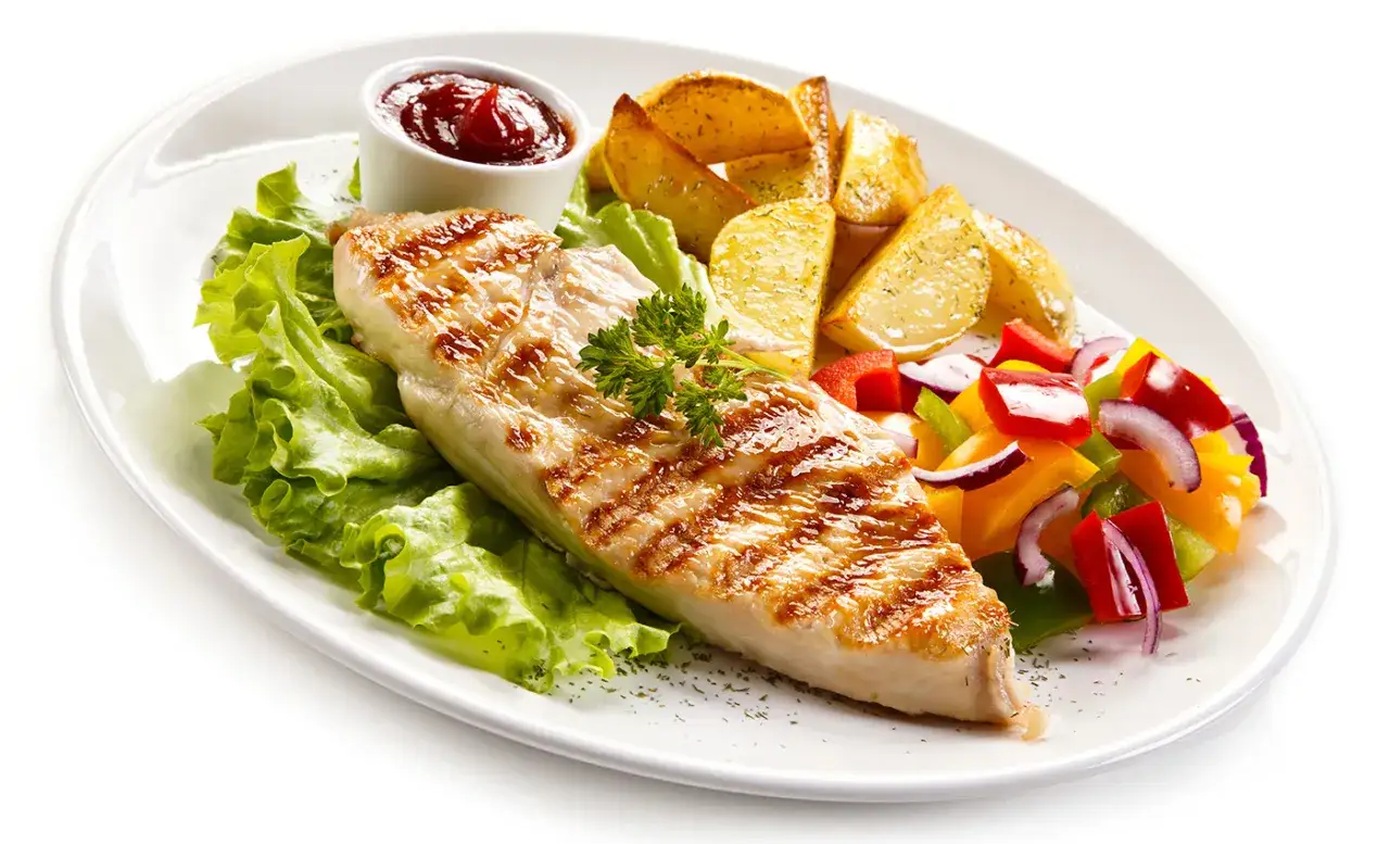 Delicioso solomillo de pollo a la parrilla con patatas asadas, ensalada de pimientos y cebolla, y una guarnici&oacute;n de lechuga fresca.