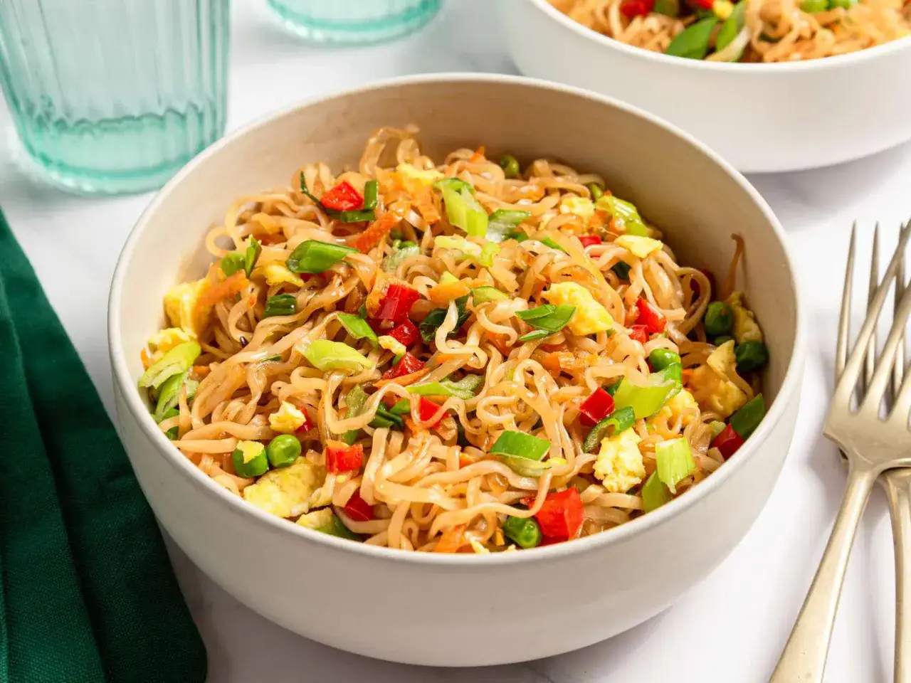En sk&aring;l med chow mein med nudlar, &auml;gg, paprika och salladsl&ouml;k.