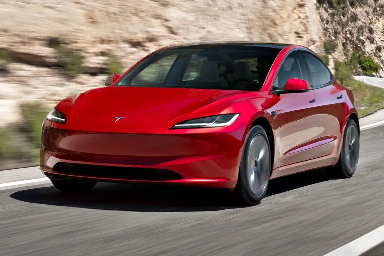Czerwony Tesla Roadster pędzi po krętej drodze. Sprawdź aktualną tesla cena i możliwości tego elektrycznego cudu.