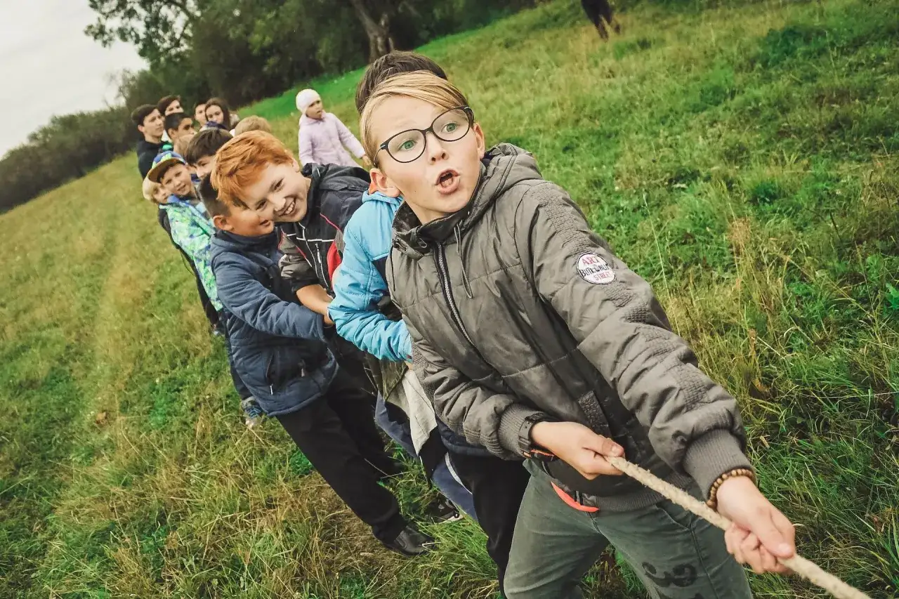 Ni&ntilde;os compiten en un juego de soga en campamentos de verano aula joven.