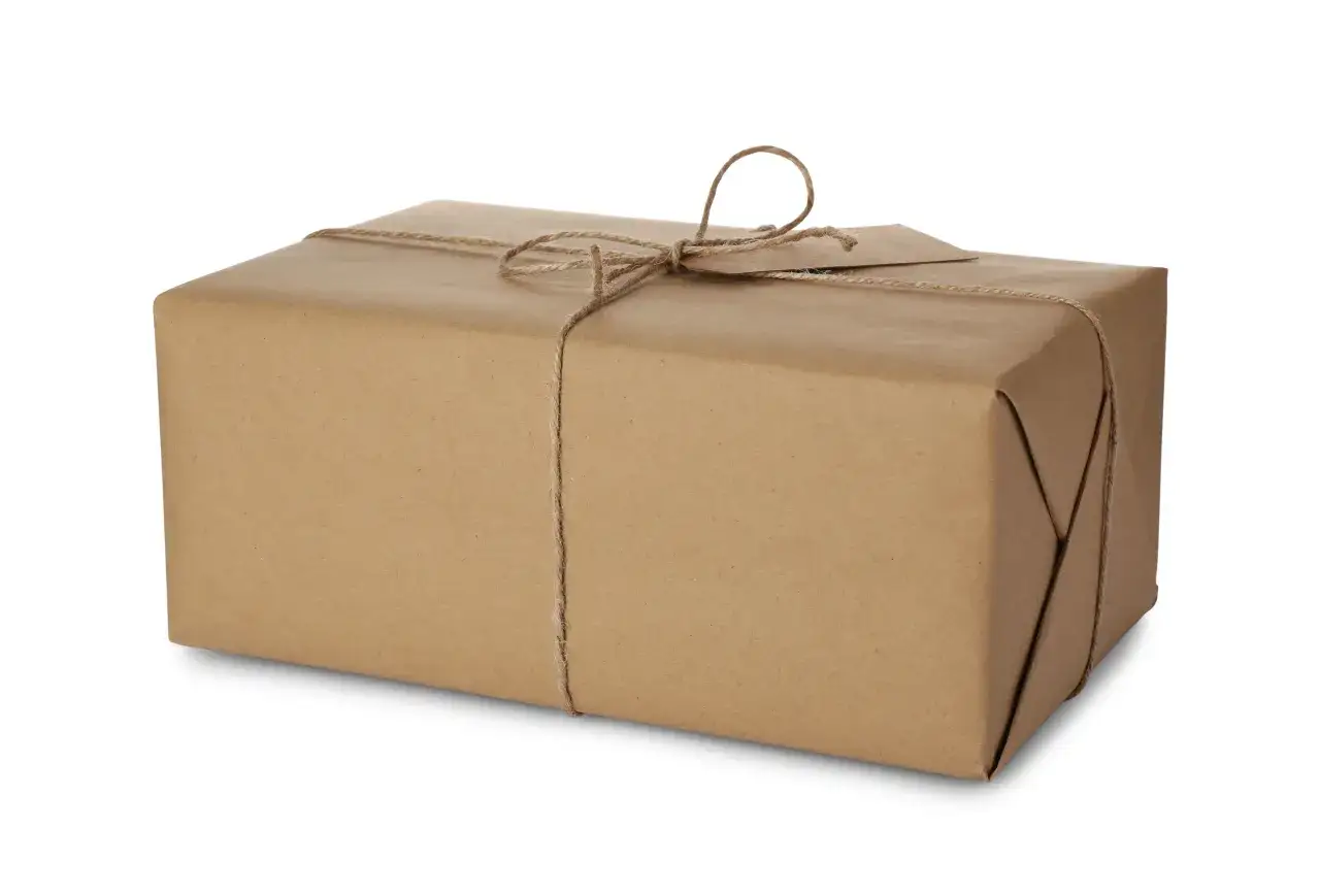 Paczka owinięta w brązowy papier, przewiązana sznurkiem. Idealna do wysyłki DHL, gdy liczą się wymiary paczki.