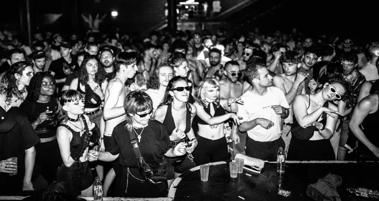 Foule dansante, ambiance techno ann&eacute;e 90. Lumi&egrave;res tamis&eacute;es, visages concentr&eacute;s et expressifs, une &eacute;nergie palpable.