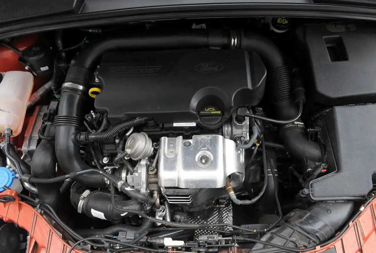 Silnik EcoBoost 1.6 TDCI w Fordzie Focus MK3. Widoczne elementy układu dolotowego i osłona silnika.
