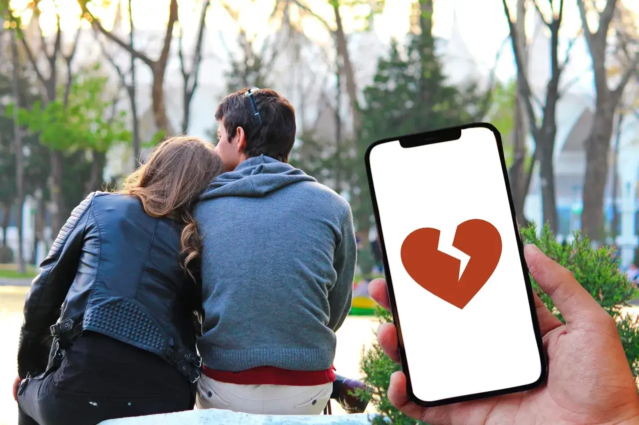 Coppia abbracciata, un telefono mostra un cuore spezzato. Si può perdonare un tradimento?