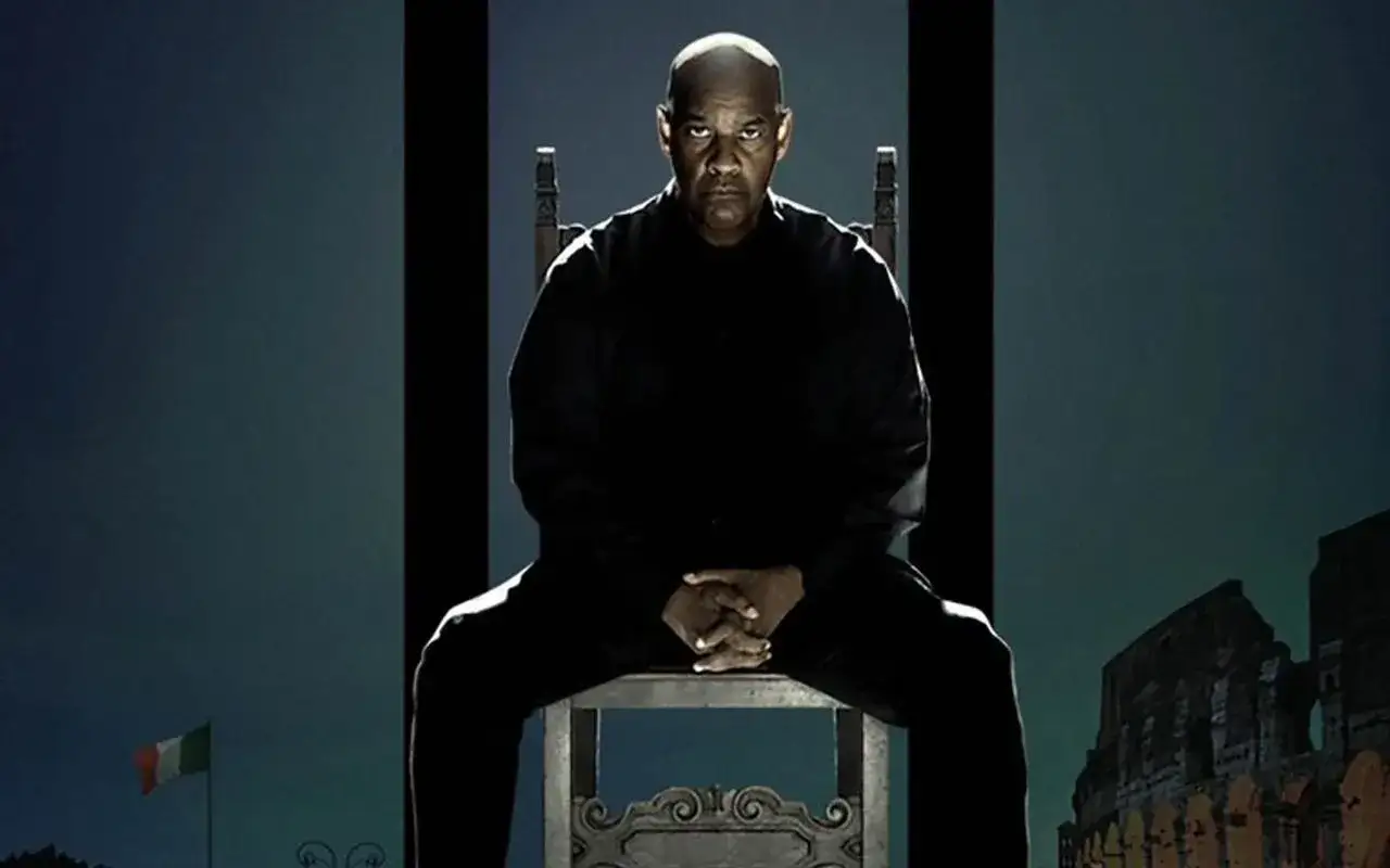 Denzel Washington siedzi na krześle, patrząc bez litości 4. W tle flaga Włoch i Koloseum.