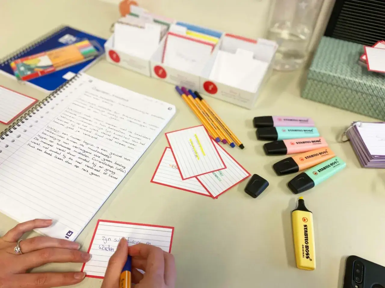 Notizbuch mit handschriftlichen Notizen und Textmarkern. Jemand lernt, Zitate zu lernen, um sein Wissen zu erweitern.
