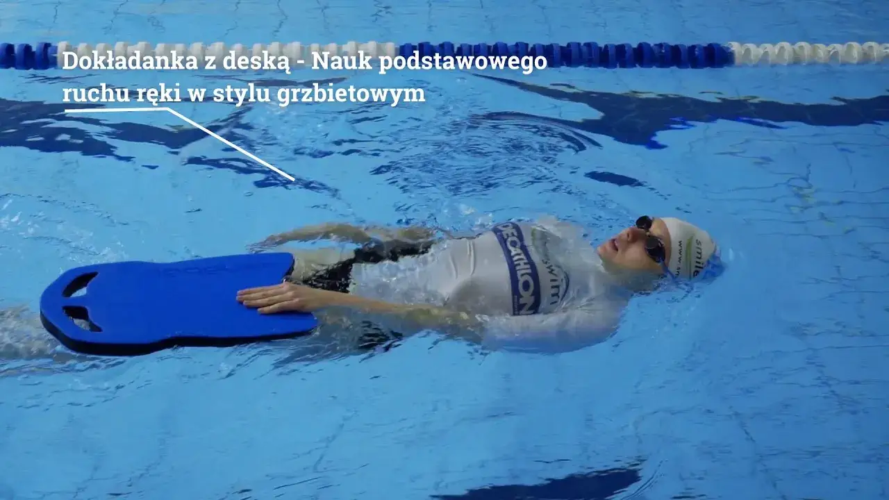 osoba dorosła na basenie uczy się pływać z deską