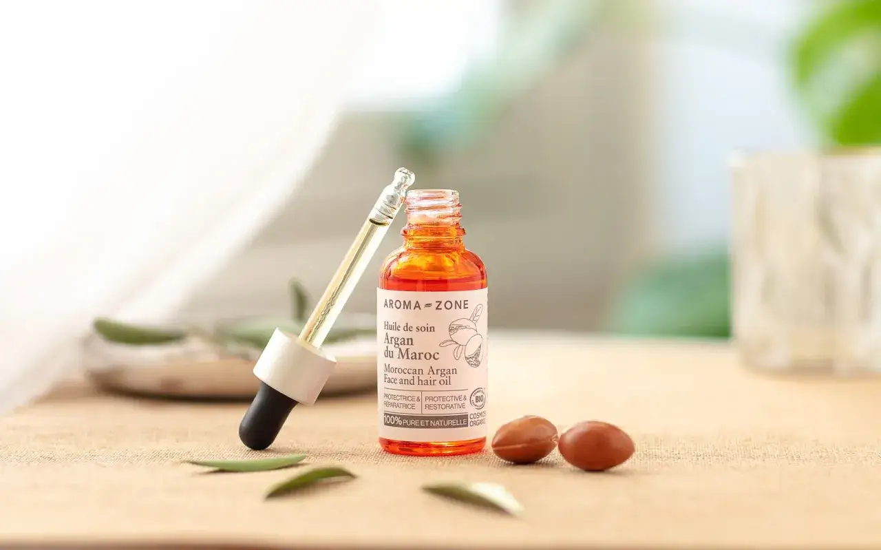 Flacon d'huile d'argan visage et cheveux, avec pipette, sur fond naturel. L'huile d'argan visage est un tr&eacute;sor de beaut&eacute;.