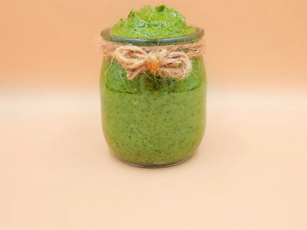 Słoik domowego pesto z rukoli, przewiązany sznurkiem. Idealne do makaronu i kanapek.
