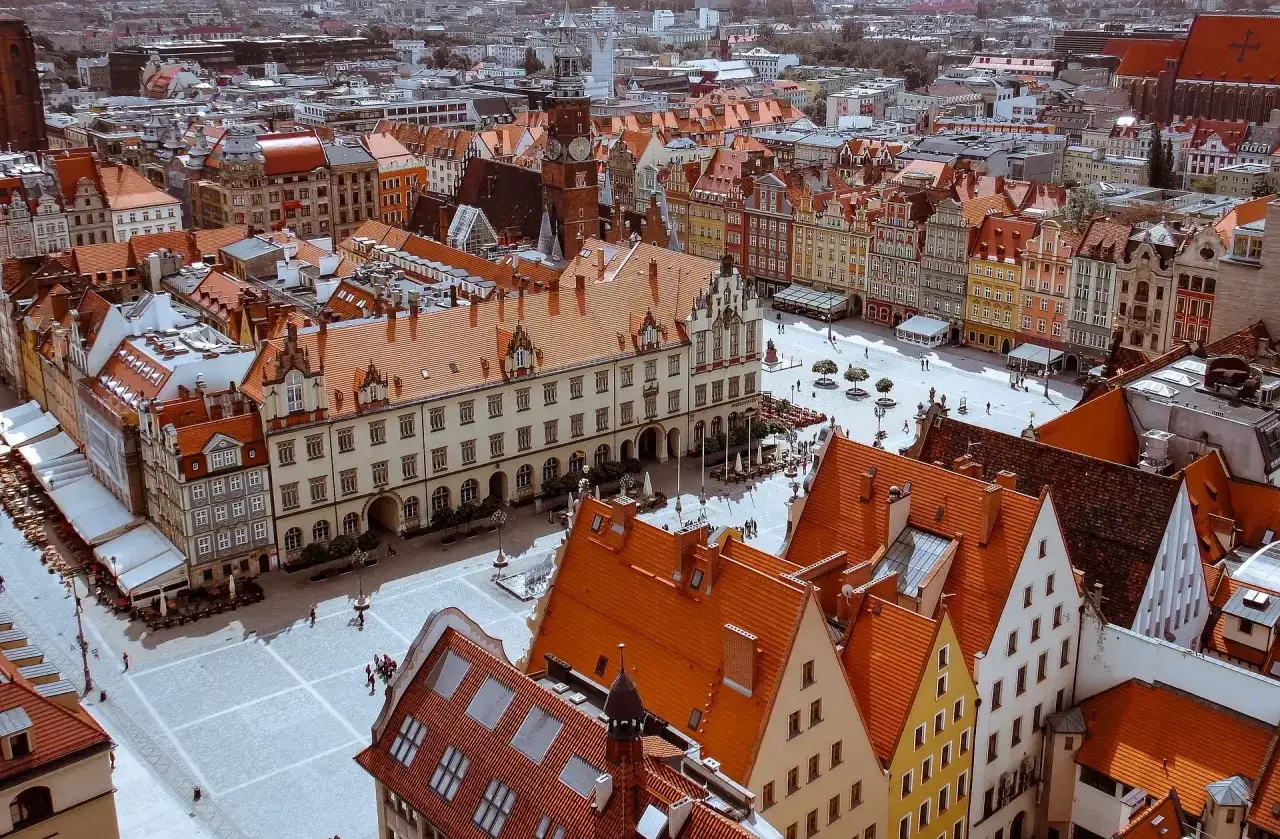 Widok z góry na Rynek we Wrocławiu z kolorowymi kamienicami i ratuszem.