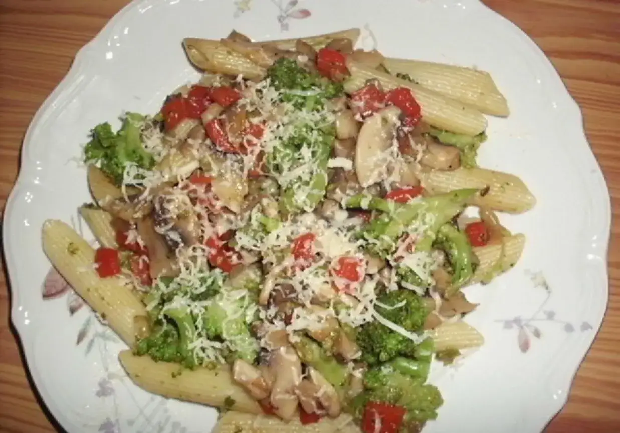 Penne z brokułami, pomidorkami i pieczarkami, posypane startym parmezanem. Pyszne makaron z warzywami.