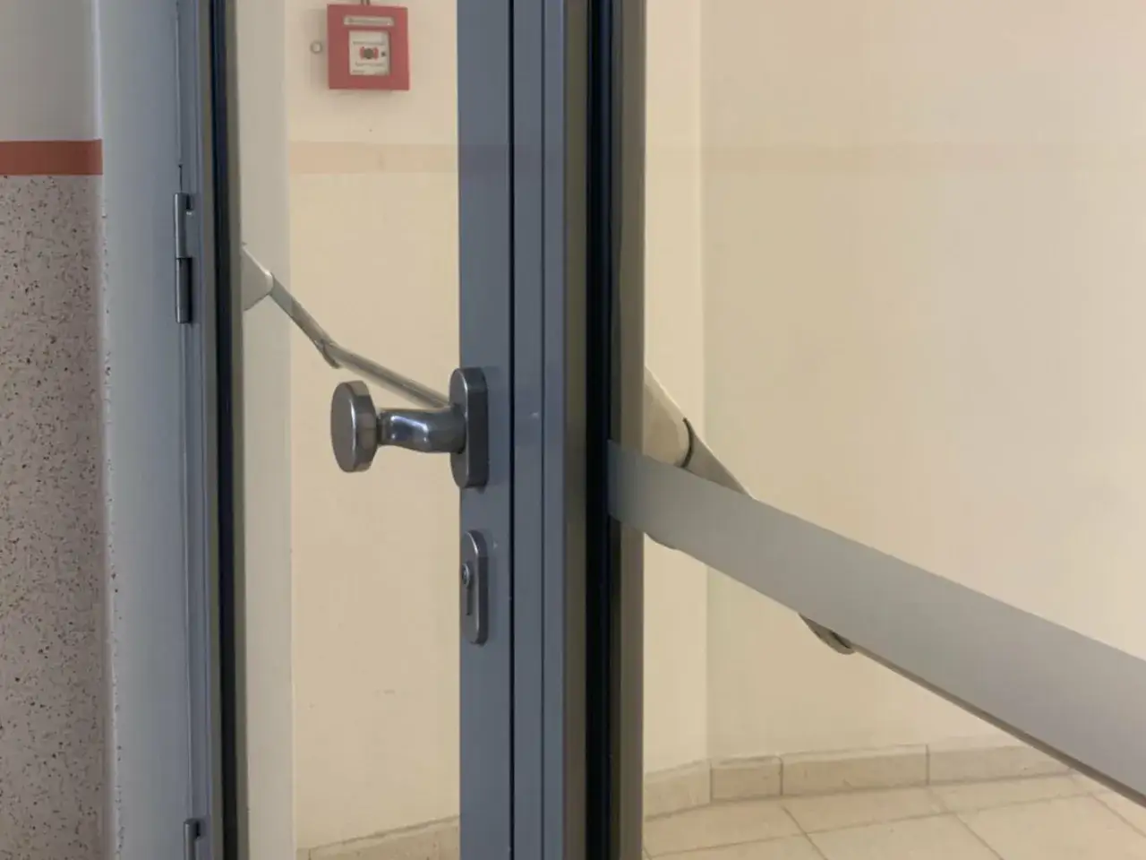 Türgriff und Panikstange an einer Glastür, die der Norm din en 179 entspricht.