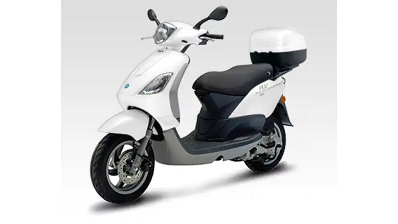 Biały skuter Piaggio Fly 50 z czarnym siedzeniem i kufrem. Idealny do miasta.