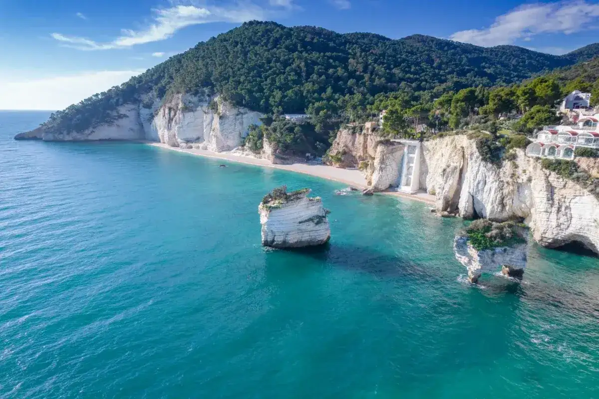 La **Baia delle Zagare**, con le sue scogliere bianche a picco sul mare turchese, incanta con faraglioni solitari e una spiaggia nascosta.