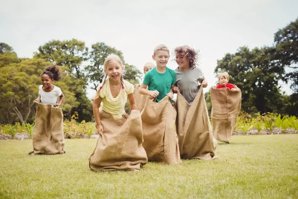 Ni&ntilde;os compiten en una divertida gymkana saltando en sacos en un d&iacute;a soleado.