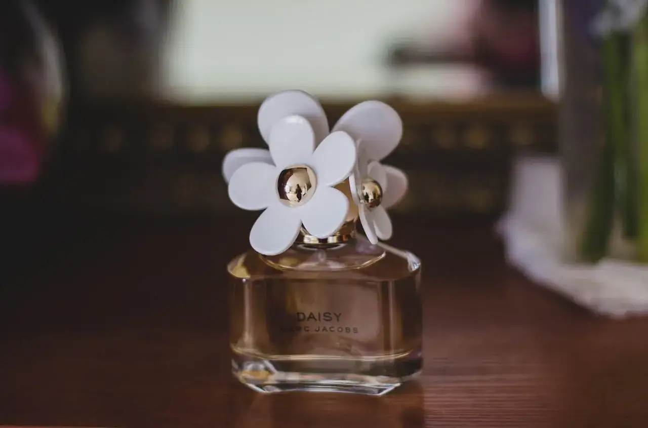 Flakon perfum Daisy Marc Jacobs z białymi kwiatkami. Czy perfumy mają datę ważności? Ten zapach wciąż zachwyca.
