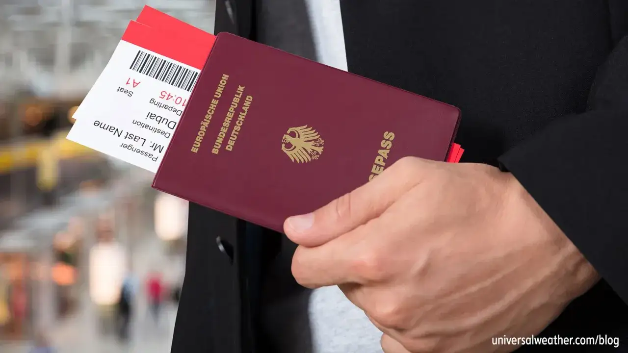 Pass och flygbiljetter redo f&ouml;r att &aring;ka till USA. En hand h&aring;ller ett tyskt pass och r&ouml;da biljetter.