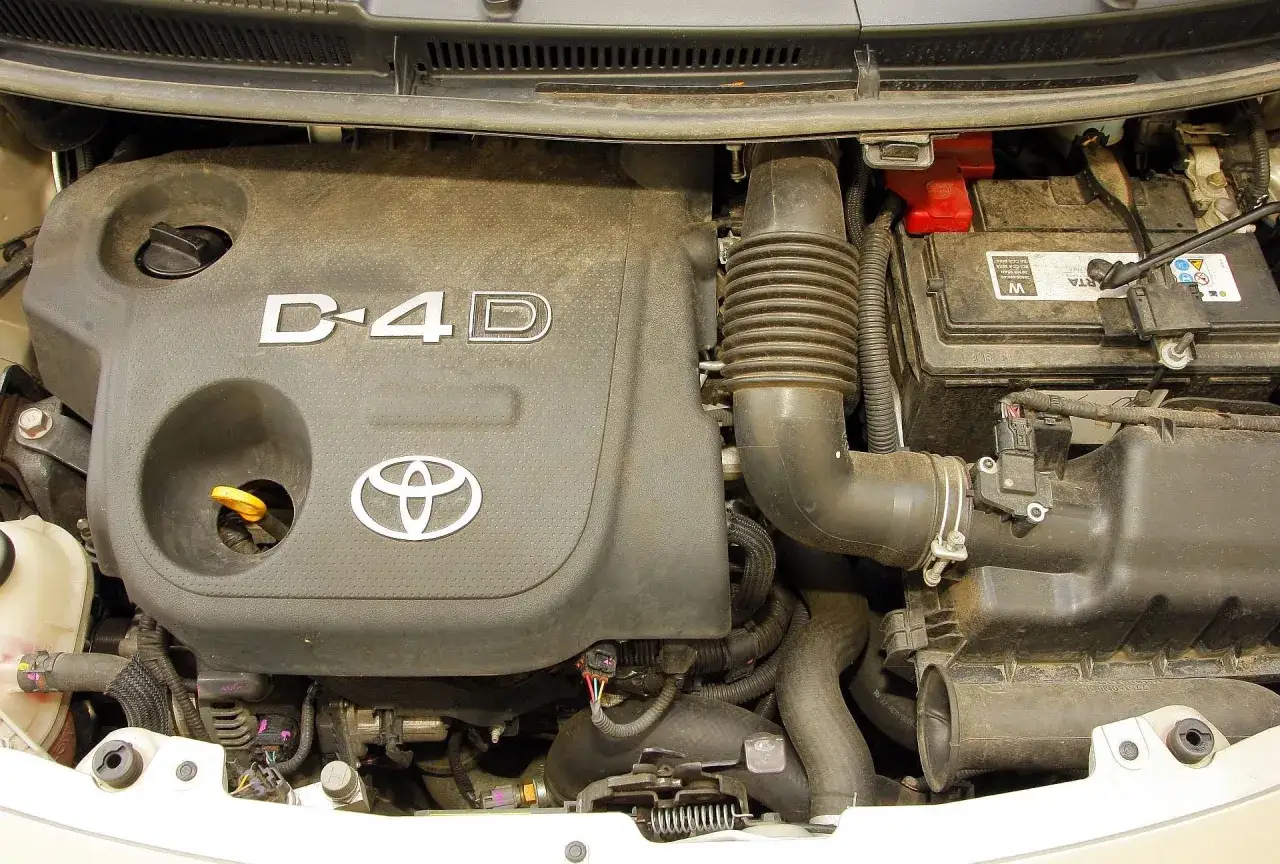 Silnik D-4D w Toyota Yaris 2009. Widoczny akumulator i elementy układu dolotowego.