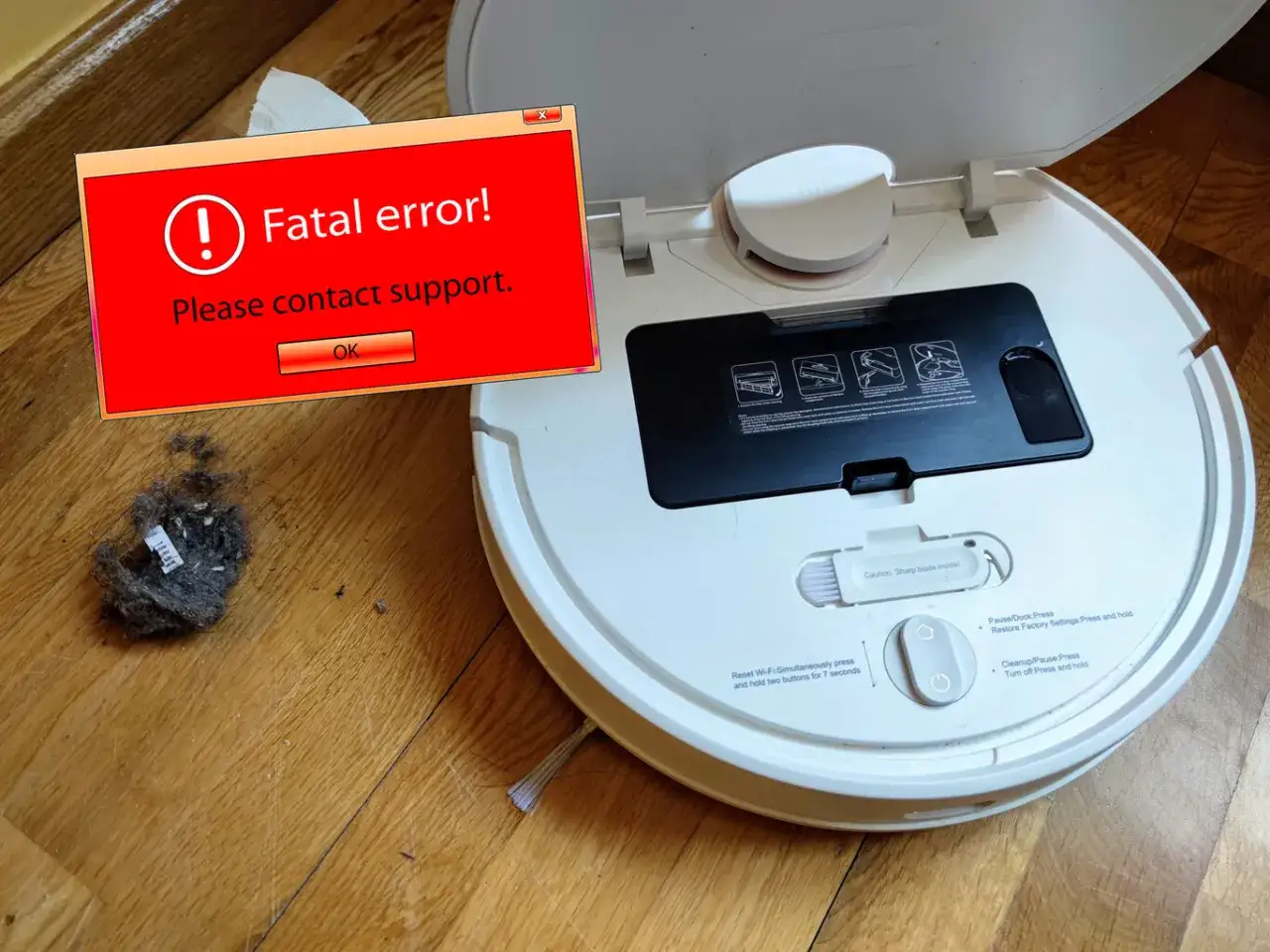 Robot aspirador Xiaomi sin wifi muestra un error fatal. Mont&oacute;n de polvo al lado.