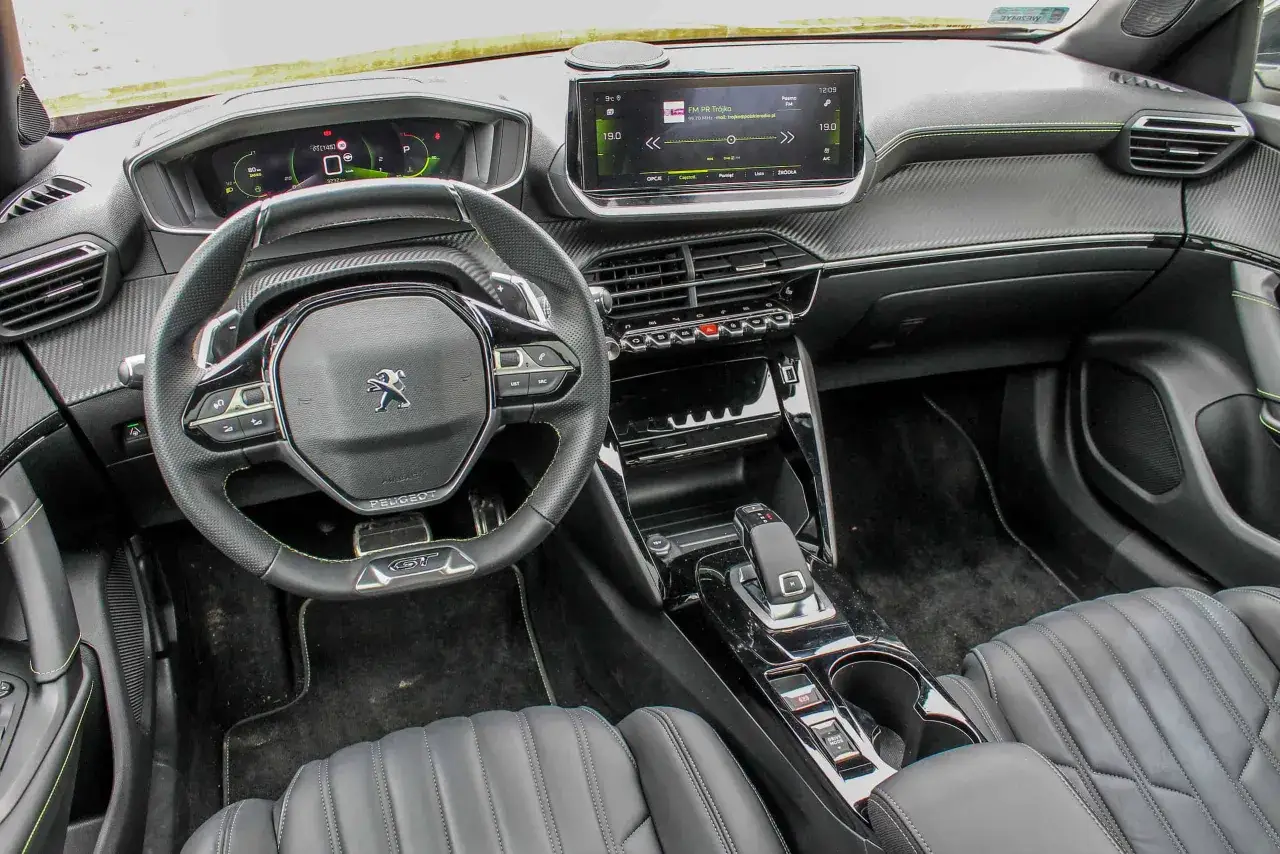 Wnętrze Peugeota 2008, z cyfrowymi zegarami i ekranem dotykowym. Wiele osób szuka peugeot 2008 opinie, by dowiedzieć się więcej o tym modelu.