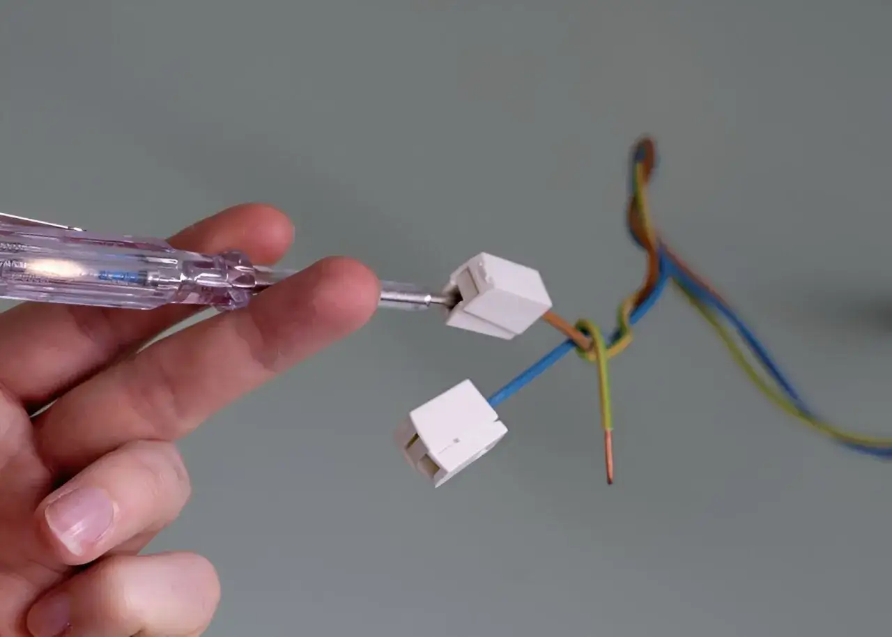 Hand pr&uuml;ft mit Schraubendreher die Kabel f&uuml;r lampen montieren.