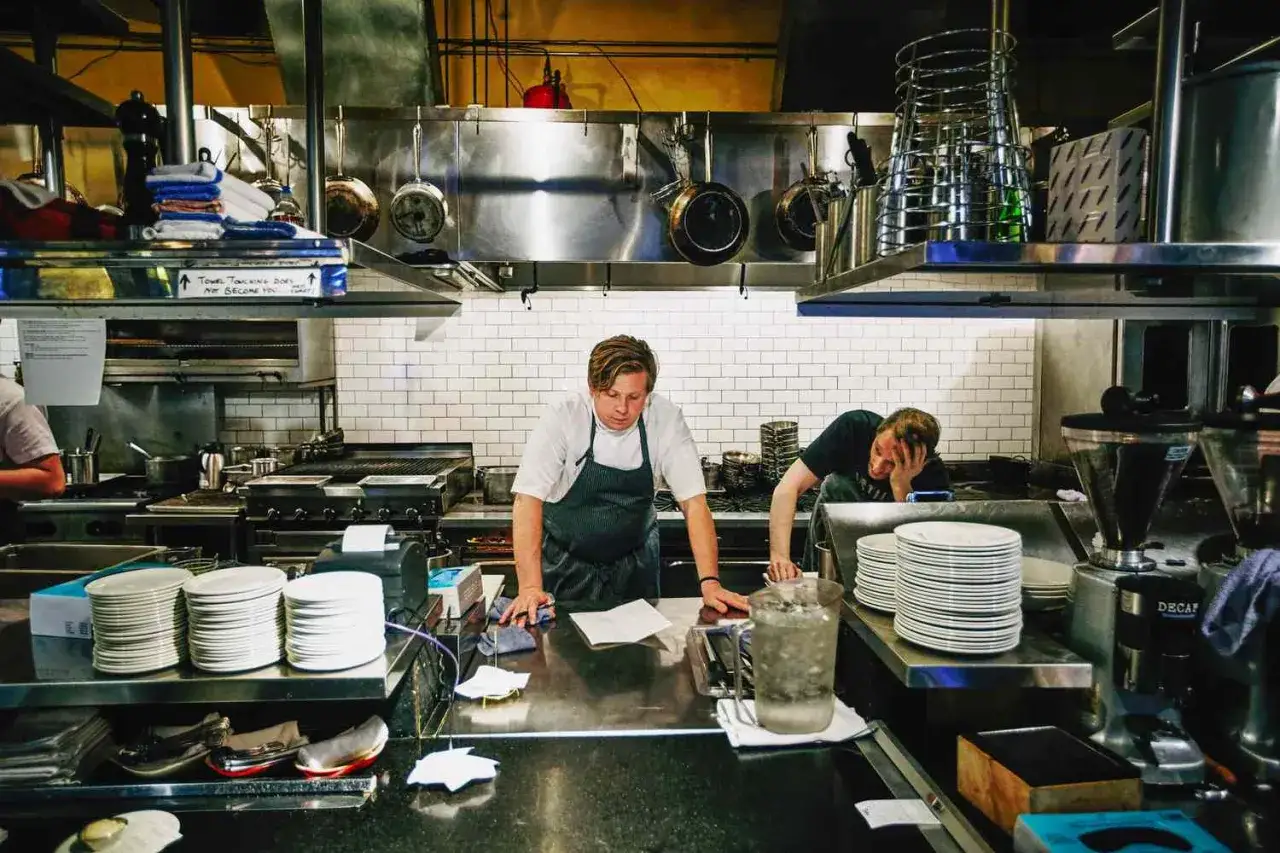 Brigada de cocina y sus funciones: chefs trabajando en una cocina profesional, preparando platos y manteniendo el orden.