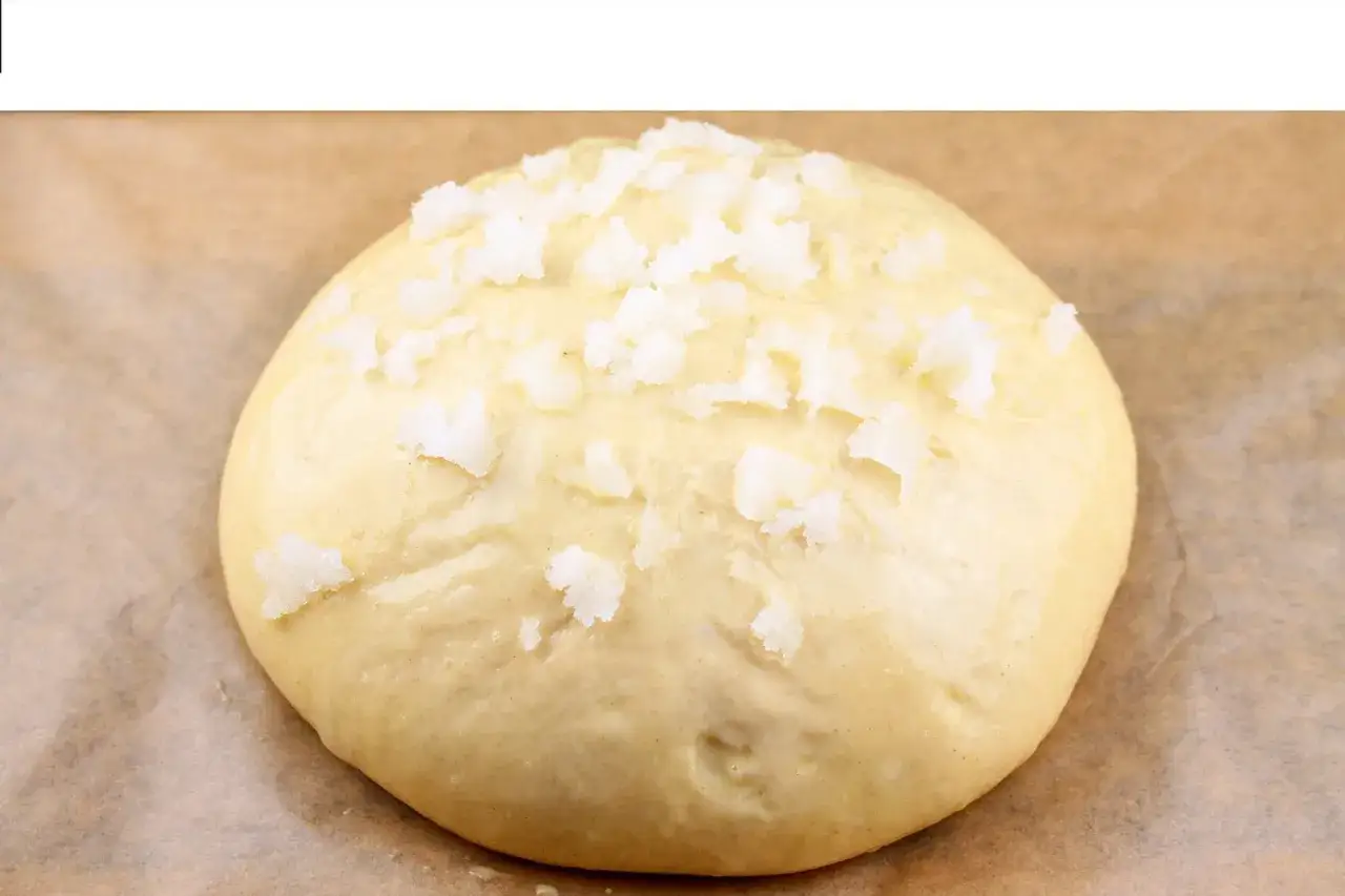Masa de pan dulce, lista para hornear, con trozos de azúcar cristalizado encima. ¡Pronto será un delicioso pan quemado!