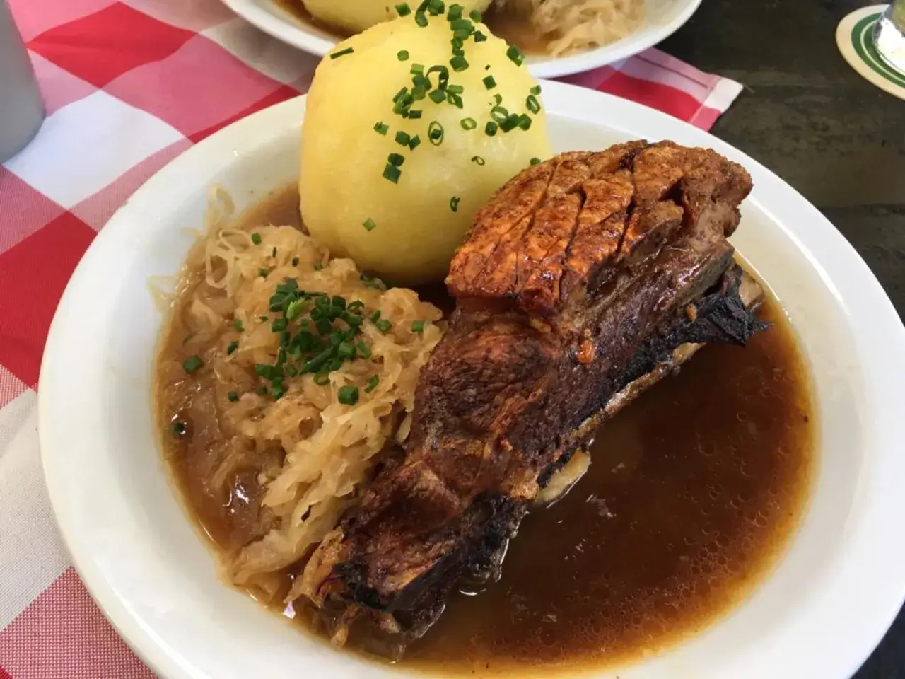 Deftig gebratenes Schweinefleisch mit Knödel und Sauerkraut, dazu eine dunkle Soße, perfekt zu einem amber ale.