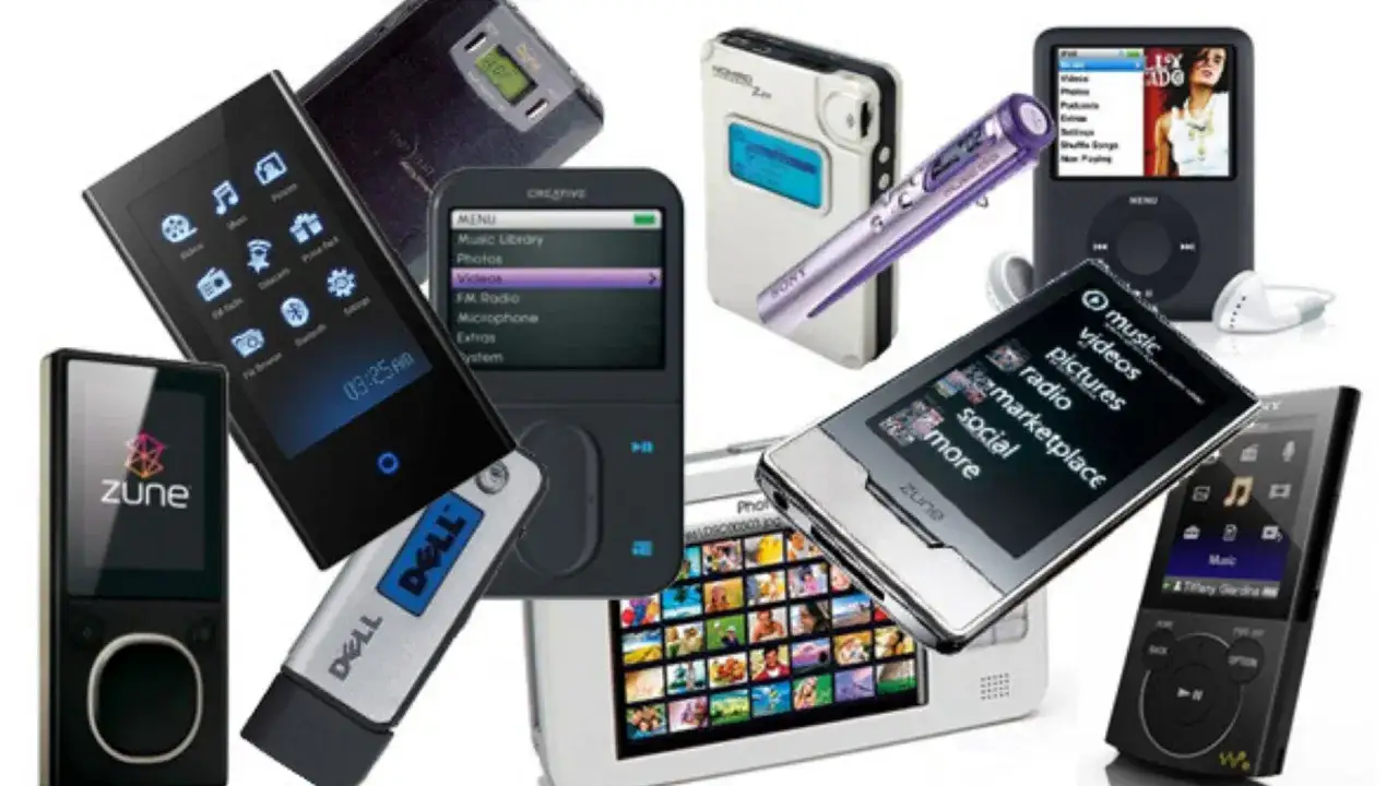 A collection of MP3 players, including iPods and Zunes, showcasing the evolution of portable music players since the MP3 format's invention.