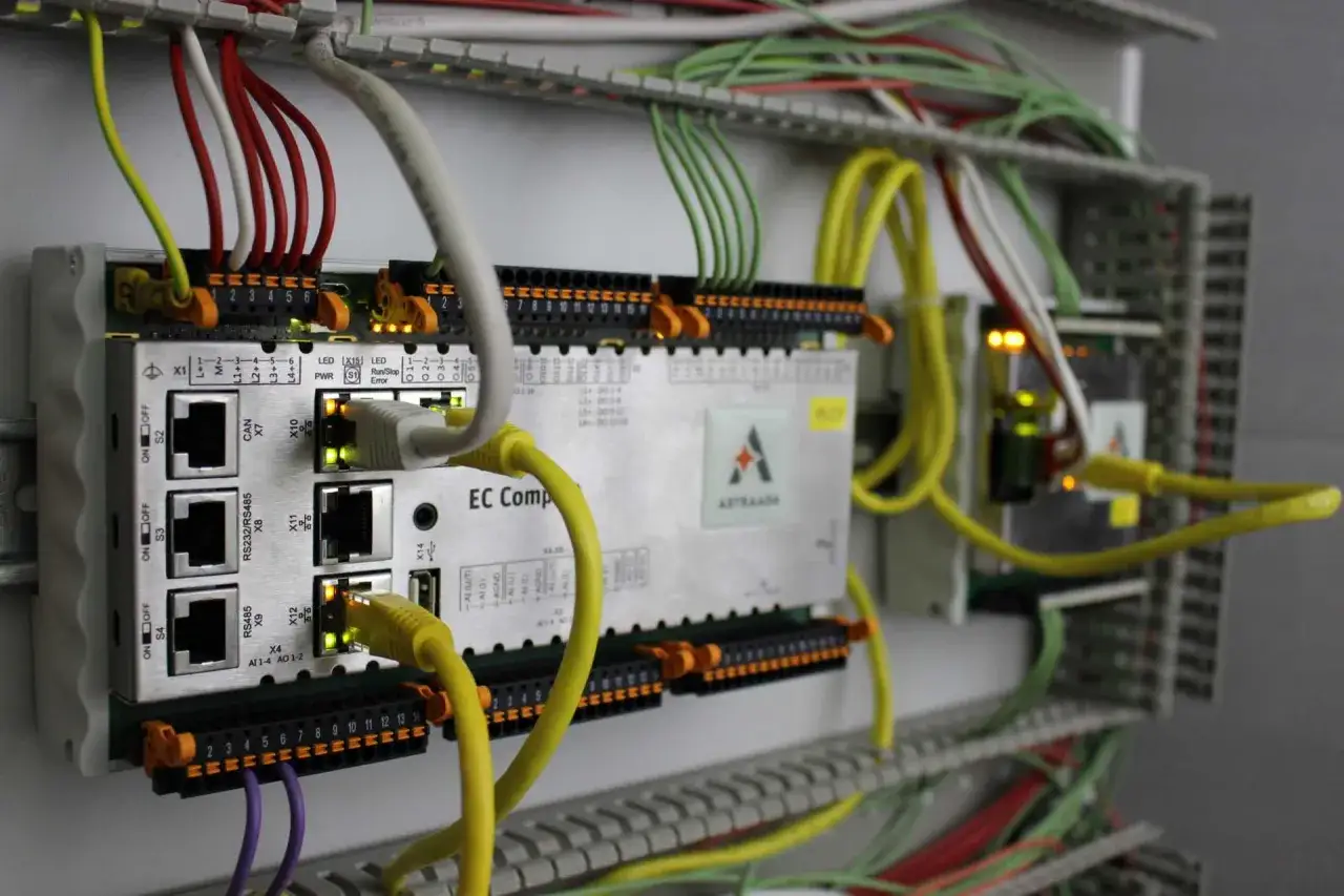 Moduł sterujący z licznymi przewodami i złączami, pokazujący podstawy automatyki przemysłowej.