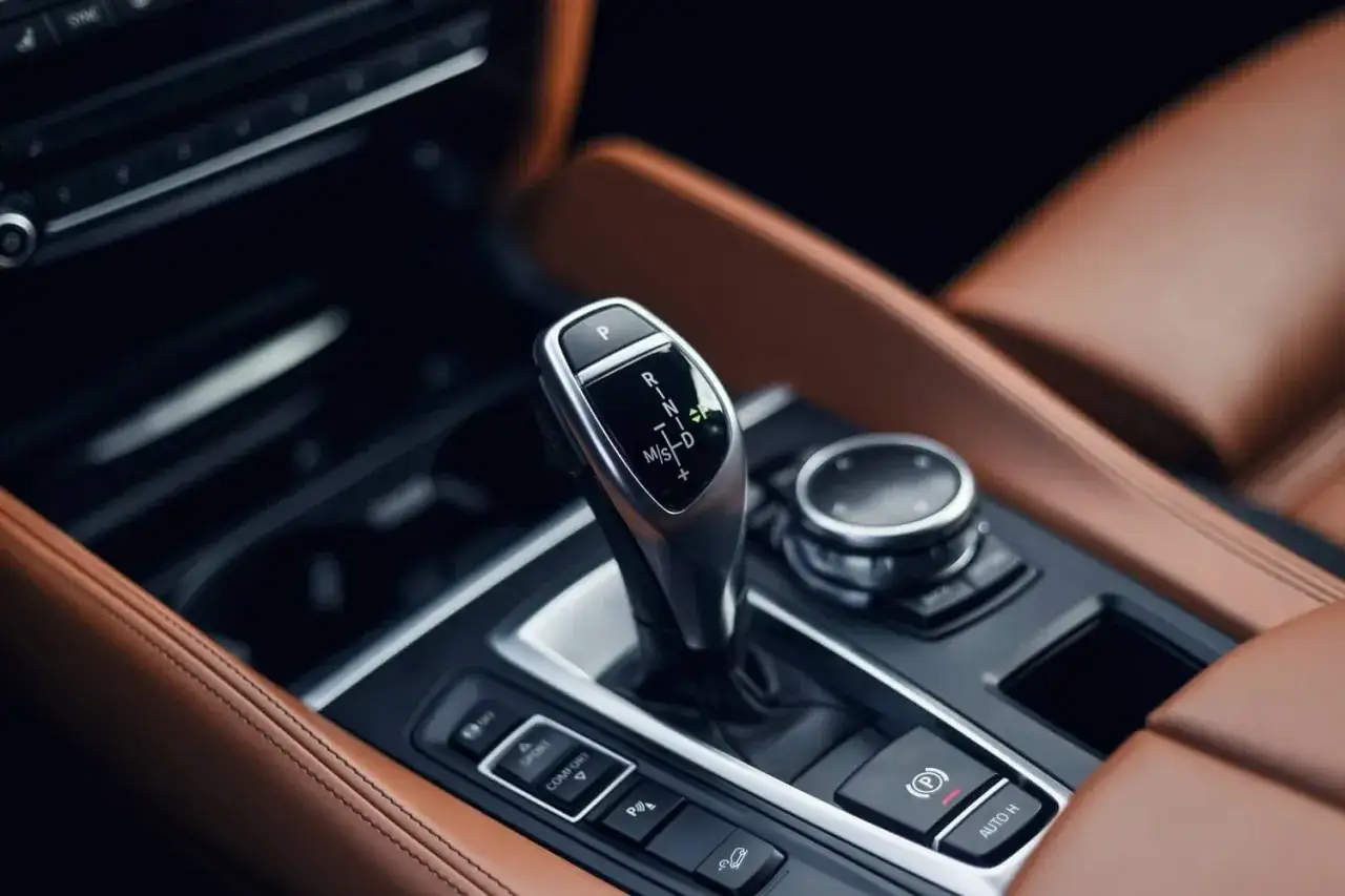 Dźwignia zmiany biegów ZF 8HP w luksusowym wnętrzu samochodu z brązową skórzaną tapicerką.