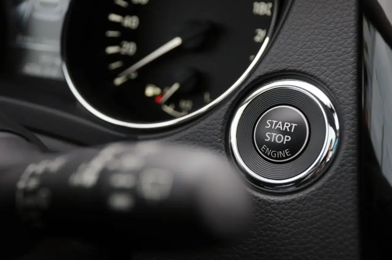 Pulsante Start/Stop Engine su cruscotto auto. Immagina di voler disattivare start e stop definitivamente per un controllo totale.