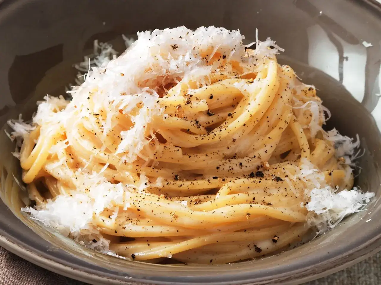 Un piatto invitante di cacio e pepe ricetta originale romana, con spaghetti cremosi, pecorino e pepe nero macinato fresco.