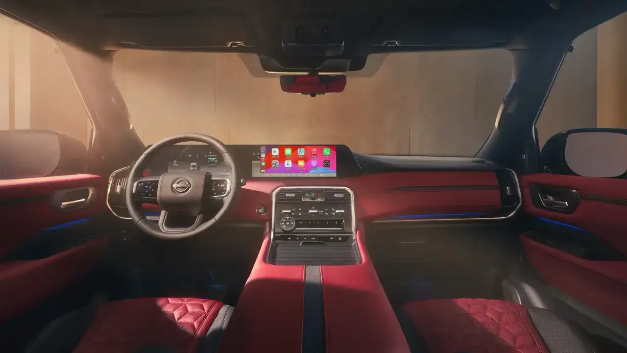Wnętrze nowego Nissan Patrol 2025 z czerwonymi akcentami i nowoczesnym ekranem multimedialnym.