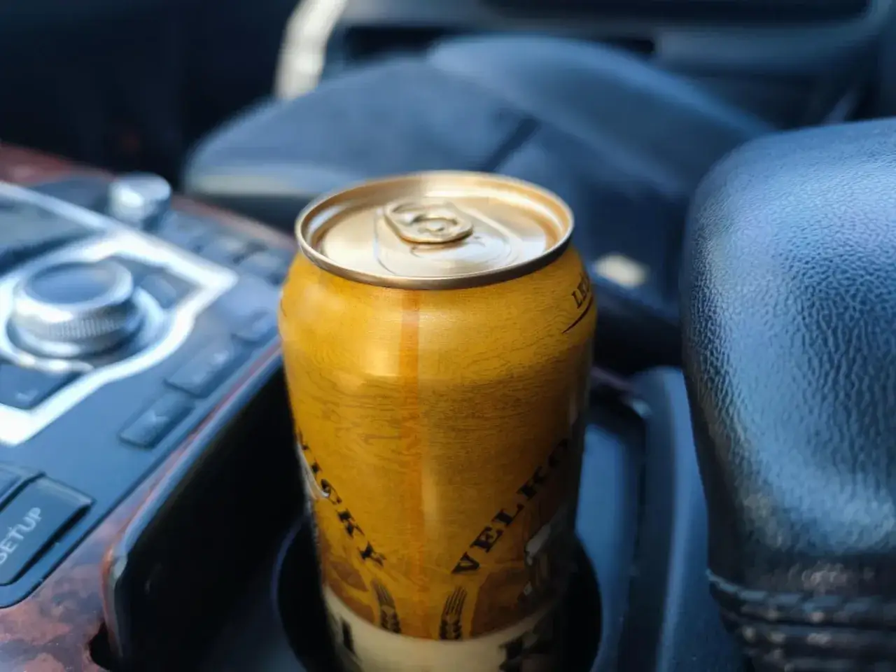 Puszka piwa w uchwycie samochodowym. Czy pasażer może pić alkohol? To zależy od przepisów i kierowcy.