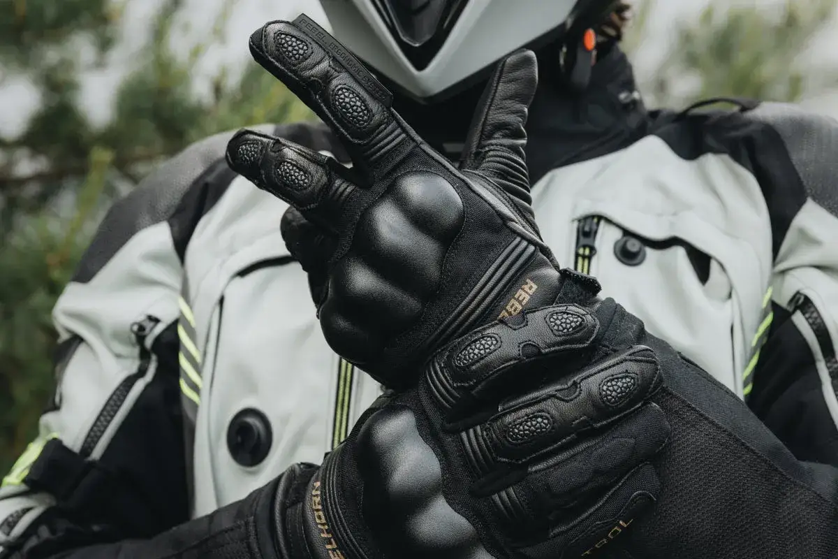 Motocyklista zaciskający pięść w rękawicy na manetce