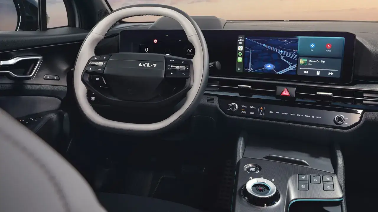 Wnętrze Kia Sportage IV z nowoczesnym ekranem multimedialnym i cyfrowymi zegarami.