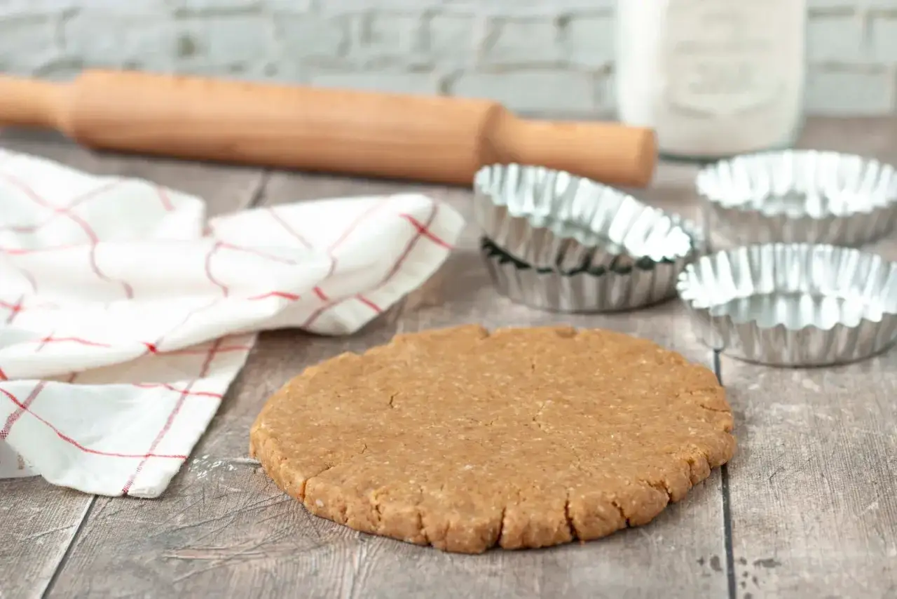 P&acirc;te sabl&eacute;e pr&ecirc;te pour la cuisson au four &agrave; chaleur tournante. Rouleau &agrave; p&acirc;tisserie, moules et torchon &agrave; proximit&eacute;.
