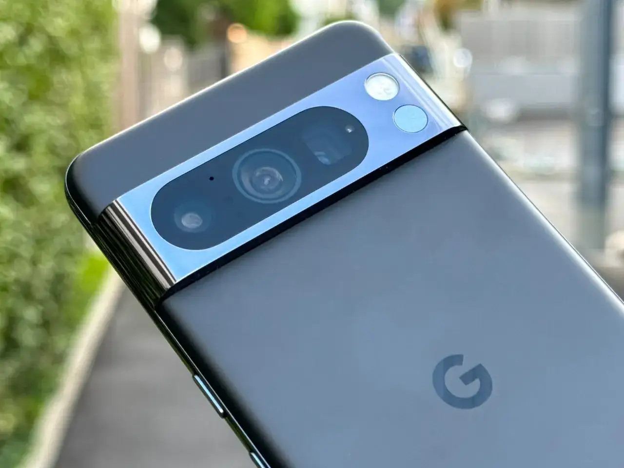 El m&oacute;dulo de c&aacute;mara del Google Pixel 10, con su distintivo dise&ntilde;o horizontal, se asoma entre el verde de la vegetaci&oacute;n.
