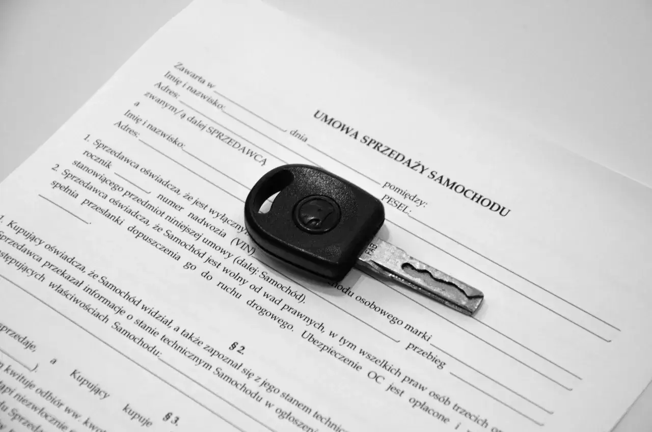 Kluczyk do samochodu leży na umowie sprzedaży. To kluczowy element, by wiedzieć, jak sprzedać auto.